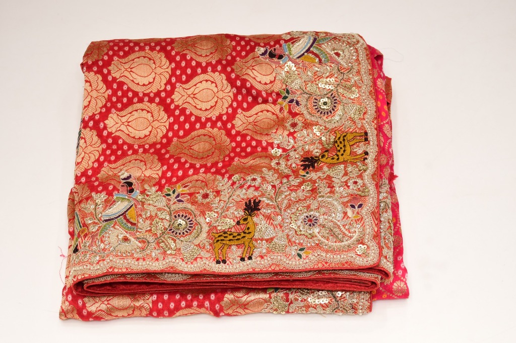 Folded red bridal saree with gold-tone floral patterns and colourful border motifs — product 02